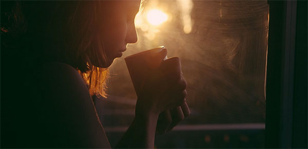 Mulher grávida tomando café